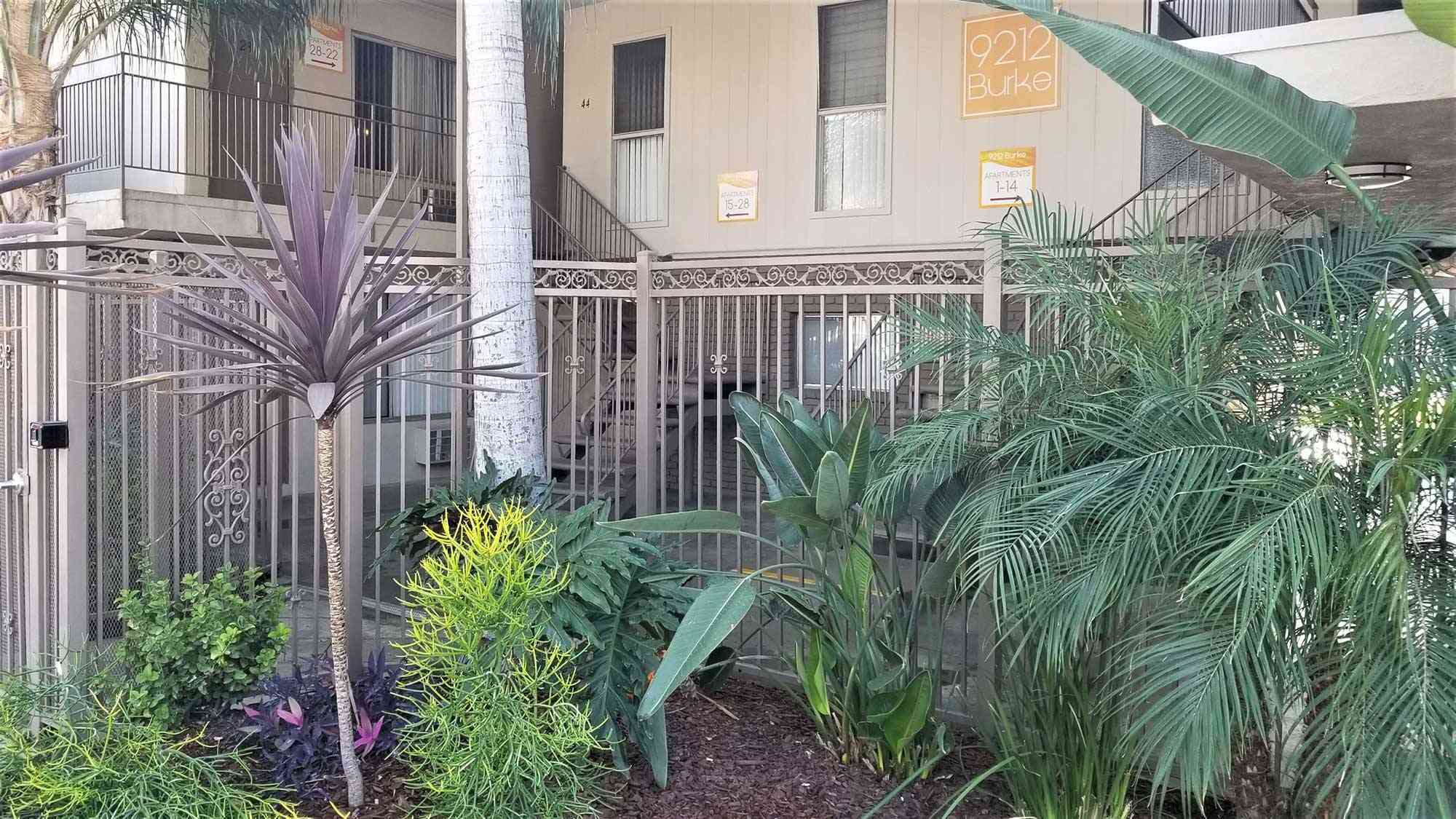 controlled access community gate with lush tropical landscaping